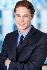 Happy young businessman smiling at the office