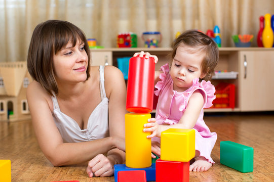 mom and child play block toys indoors