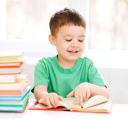 Little boy is reading a book