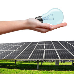 Solar energy panels and bulb in hand