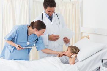 Fototapeta premium Doctors examining sick girl
