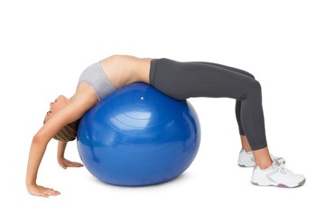Fototapeta premium Fit young woman stretching on fitness ball