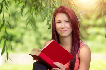 L&auml;chelnde Studentin mit rotem Buch