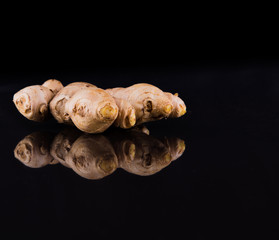 Fresh ginger root over black background
