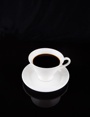 Obraz na płótnie Canvas Coffee in a white cup over black background
