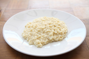 risotto dish with herbs on wood background
