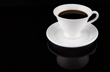 Coffee in a white cup over black background