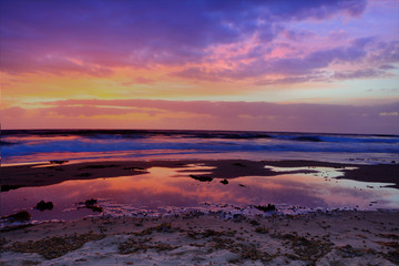 Red dawn and cloud reflections at the beach