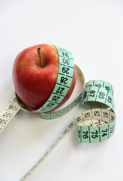 Apple and measurement tape on the white background