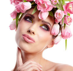 Portrait of a beautiful spring girl wearing flowers hat. Studio