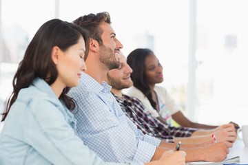 Smiling team of designers listening at meeting