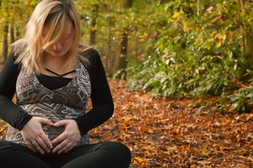 Pregnant woman with a heart ship in the forest