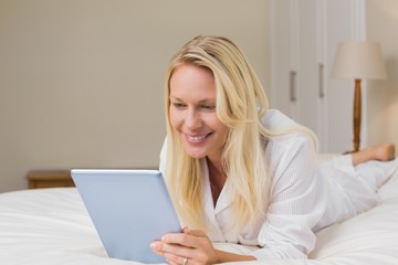 Fototapeta premium Woman using digital table while lying in bed