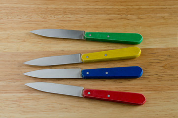 knives on wood, red, yellow, blue, green