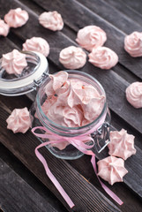 Obraz na płótnie Canvas Pink meringues in a glass jar