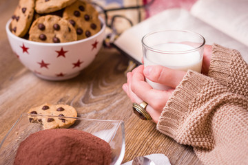 Female hands with hot drink and chocolate cookies