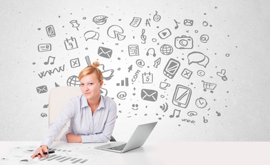 Young businesswoman with all kind of hand-drawn media icons in b