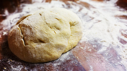Fototapeta na wymiar A bun of leavened dough in flour