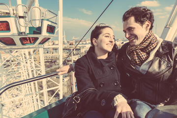 Young Couple having a Ride on a Ferris Wheel