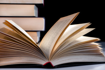 Buch aufgeschlagen vor Bücherstapel