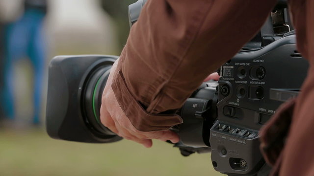 Cameraman filming outdoors. Close-up
