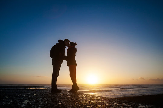 Romantic photo of kissing couple during sunset