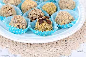 Set of chocolate candies, on plate, on wooden background