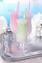 Milk shakes on table on light blue background
