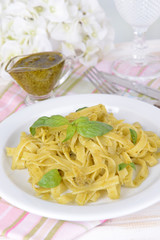 Delicious pasta with pesto on plate on table close-up