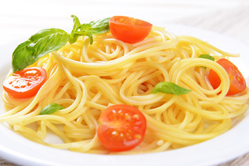 Delicious spaghetti with tomatoes on plate on table close-up