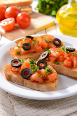 Delicious bruschetta with tomatoes on plate on table close-up