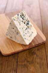 Tasty blue cheese, on wooden table