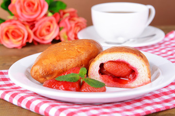 Fresh baked pasties with strawberries on plate on table