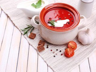 Tasty tomato soup and vegetables on wooden table
