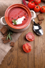 Tasty tomato soup on wooden table