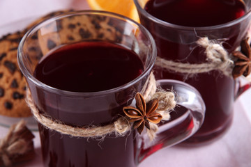 Mulled wine with cookies on table close up