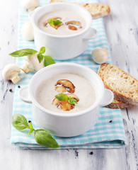 Mushroom soup in white pots, on napkin,  on wooden background