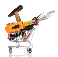 Construction tools in shopping cart isolated on white