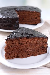 Delicious chocolate cake on plate on table on light background