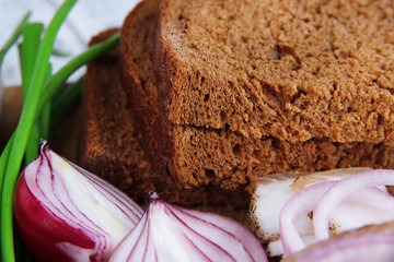 Rye bread with onion on table close up