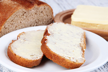 Rye bread with butter on cutting board close up