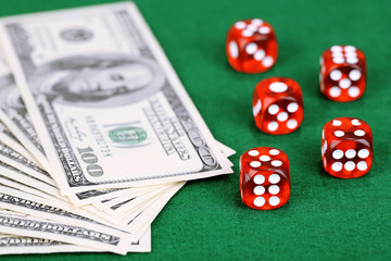 Red dices and dollars on green background