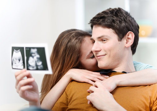 Beautiful couple watching with emotion ultrasound pictures of th