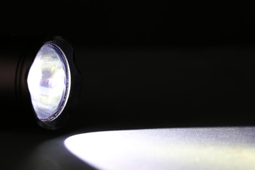Beam from flashlight closeup on dark background - obrazy, fototapety, plakaty
