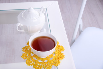 Composition with cup of hot drink, candle and flowers