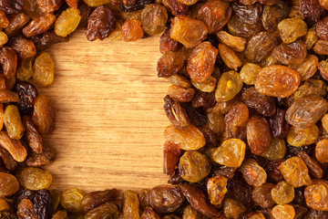Diet healthy food. Border of raisin on wooden background