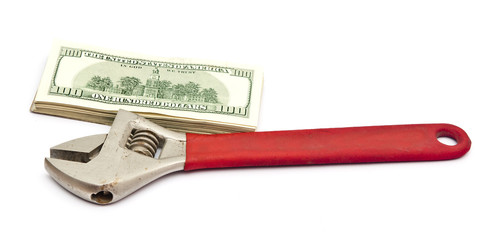 Wrench and bills of U.S. dollar currency isolated on white backg