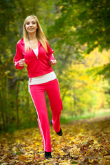 Woman running in autumn forest.  Female runner training.