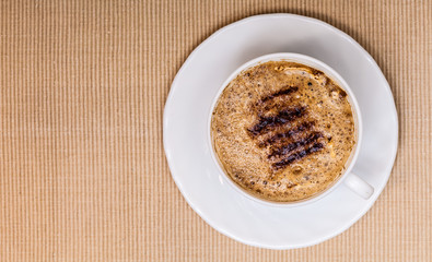 Coffee hot beverage drink with froth on brown background