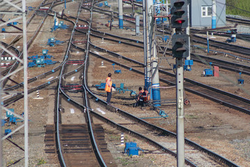 Railways and workers in overalls, serving railroad tracks